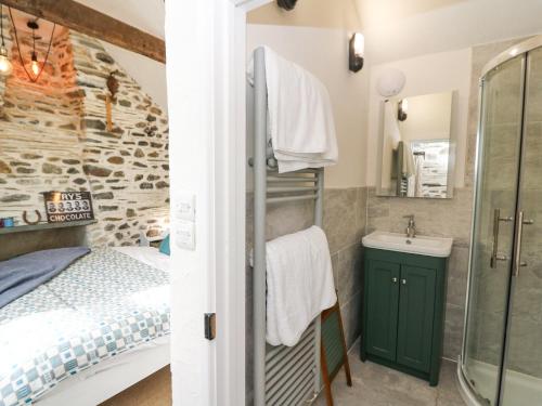 a bathroom with a bed and a shower and a sink at Dyffryn Cottage in Cardigan