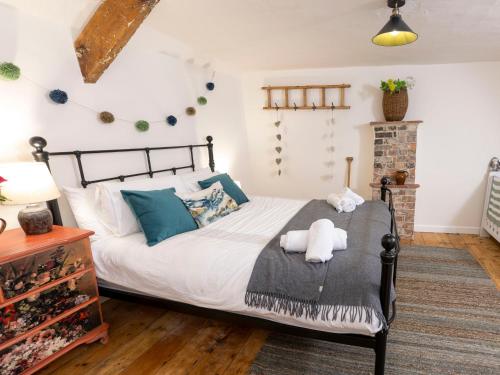 a bedroom with a bed with white sheets and blue pillows at Dyffryn Cottage in Cardigan
