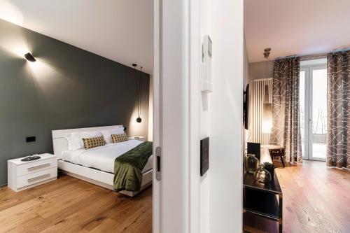 科莫Hidden Lodge - by MyHomeInComo的卧室里有一张白色的床和一扇大窗户