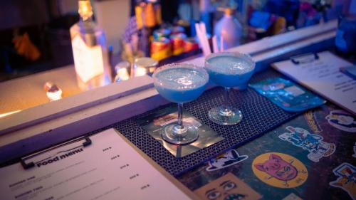 two wine glasses sitting on top of a bar at MESTO Koh Phangan - Creative Stay & Community Hub in Thongsala