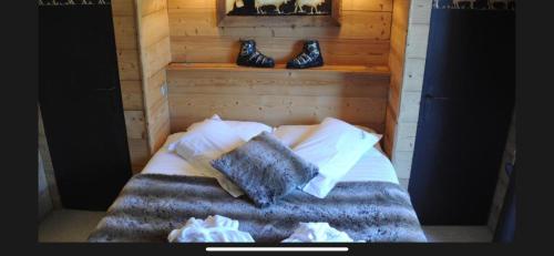 a bedroom with a bed with a pair of shoes on a shelf at Hôtel Chalet Alpage in La Clusaz