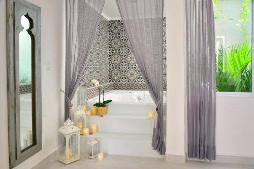 a bathroom with a bath tub and stairs with a window at Unic Design Hotel - 5th Avenue in Playa del Carmen