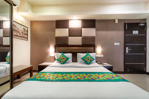 a bedroom with a large bed with a large headboard at Treebo Venition Inn in Coimbatore
