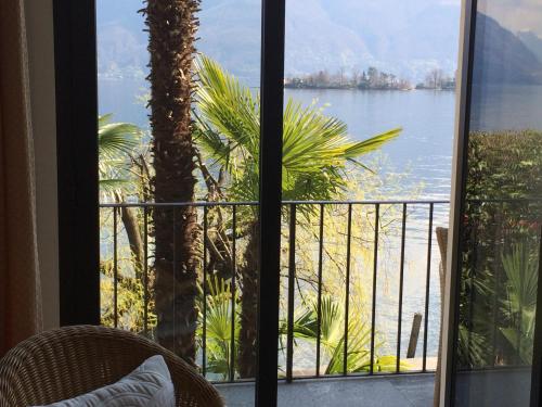 a room with a view of the water from a balcony at Art Hotel Ristorante Posta Al Lago in Ronco s/Ascona - Porto Ronco