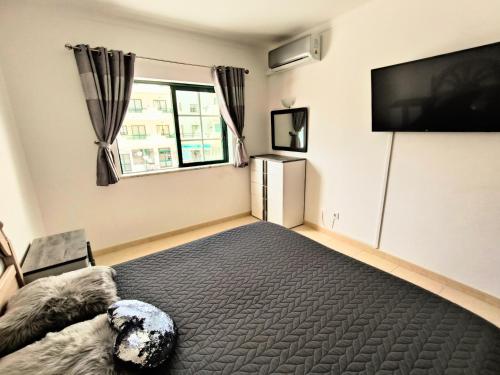 a bedroom with a bed and a flat screen tv at DUNAS DO ALVOR by LTS Holidays - #127 in Alvor