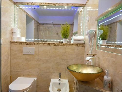 baño con lavabo de oro y aseo en Apartamenty Dworcowa 5, en Szklarska Poręba