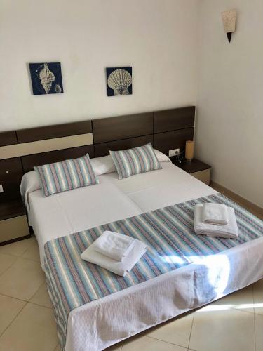 Un dormitorio con una cama grande con dos toallas encima. en Solmar menorcacom apartamento 2 dormitorios, en Cala'n Bosch
