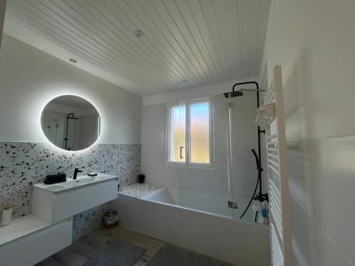 a bathroom with a tub and a sink and a mirror at Maison 4 chambres & jardin à Chéray in Saint-Georges-dʼOléron