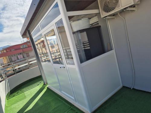 an open door on a balcony with green flooring at Attico Solaris in Reggio Calabria