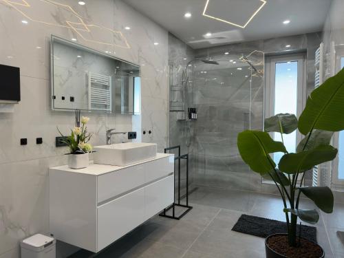 a white bathroom with a sink and a shower at Cityferienwohnung in Emmerich
