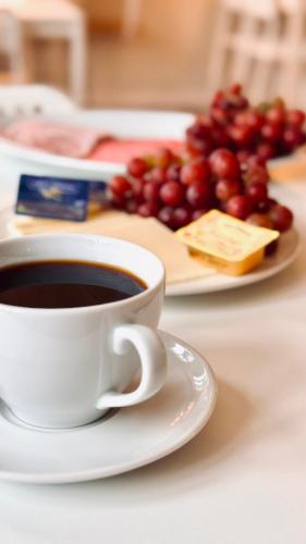 a cup of coffee next to a plate of grapes at Jerup Bed & Breakfast in Jerup