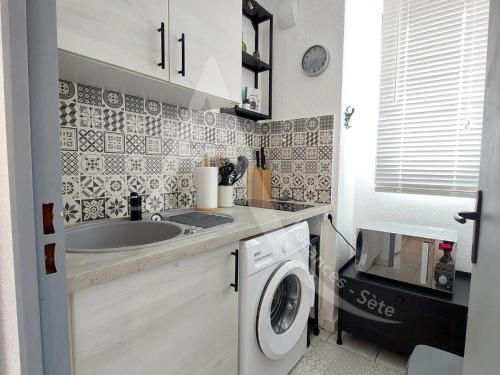 une cuisine avec un évier et une machine à laver dans l'établissement T3 avec terrasse, climatisation et parking, à Sète