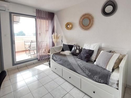 - une chambre avec un lit et deux miroirs sur le mur dans l'établissement T3 avec terrasse, climatisation et parking, à Sète