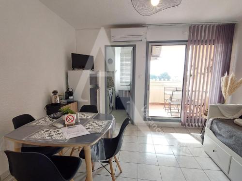 un salon avec une table et des chaises dans une pièce dans l'établissement T3 avec terrasse, climatisation et parking, à Sète
