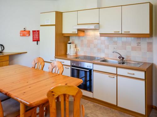 a kitchen with a wooden table and a sink at Apartment Kassler-1 by Interhome in Kappl