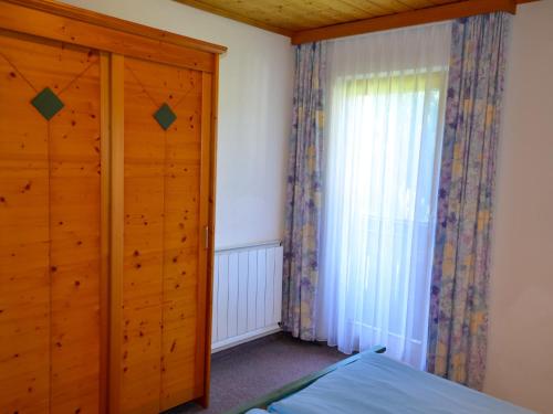 a bedroom with a wooden door and a window at Apartment Kassler-1 by Interhome in Kappl