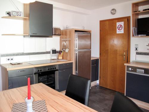 a kitchen with a table and a kitchen with a refrigerator at Apartment Miramonte-3 by Interhome in Kappl