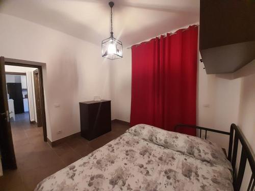 Zimmer mit einem Bett, roten Vorhängen und einem Tisch in der Unterkunft The Mountain View - Casa a Castello in Castel di Sangro
