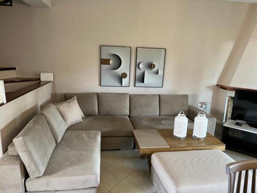 a living room with a couch and a table at Peaceful modern holiday vila in Skála Foúrkas