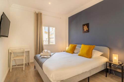 une chambre avec un grand lit avec des oreillers jaunes dans l'établissement Hellenica - Proximité gare, à Marseille