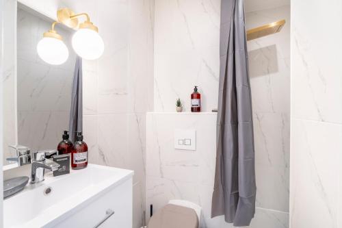 une salle de bain blanche avec un lavabo et une douche dans l'établissement Hellenica - Proximité gare, à Marseille