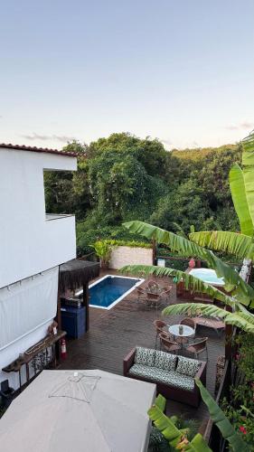 a backyard with a pool and tables and chairs at Pousada Del Mares in Fernando de Noronha