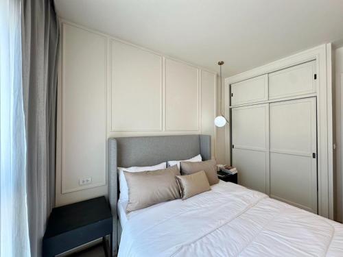 a bedroom with a large white bed with pillows at DLUX 7TH Floor in Ban Klang