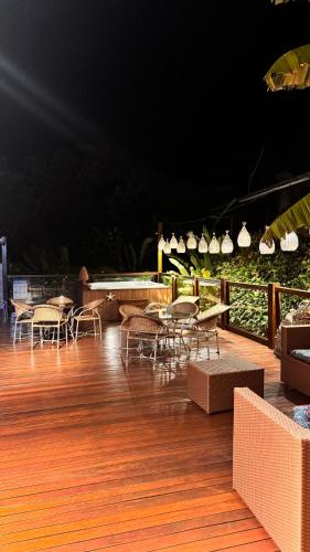 a wooden deck with chairs and tables and lights at Pousada Del Mares in Fernando de Noronha