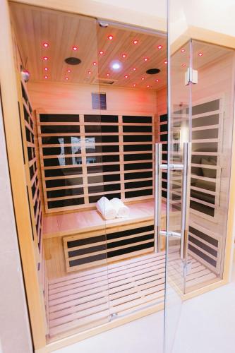 a sauna with a glass wall in a room at Sauna - Massage - Double Shower - Luxe in Romans in Romans-sur-Isère