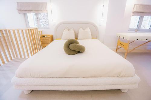 a white bed with a hat on top of it at Sauna - Massage - Double Shower - Luxe in Romans in Romans-sur-Isère