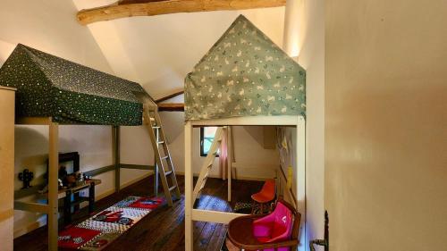 a childs room with a bunk bed and a ladder at La Charreterie in Auzouville-sur-Saâne