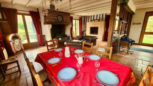 a dining room with a table with a red table cloth at La Charreterie in Auzouville-sur-Saâne