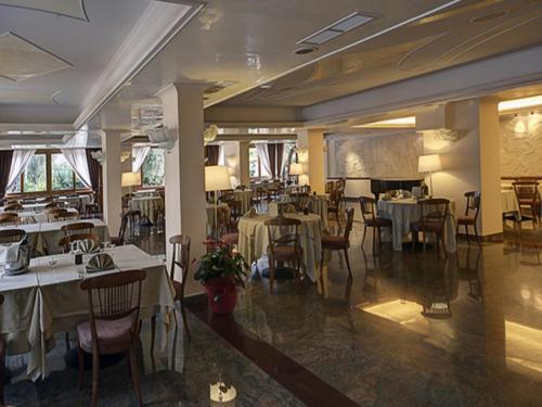 ein Restaurant mit Tischen und Stühlen in einem Zimmer in der Unterkunft Hotel Apeneste in Mattinata