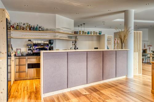 a kitchen with wooden floors and a counter top at Hotel Berghaus Rosengarten in Nova Levante