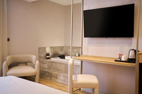 a hotel room with a television and two chairs at La Maja Hotel in Antalya