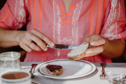 a woman is eating a piece of food on a plate at Hotel Berghaus Rosengarten in Nova Levante