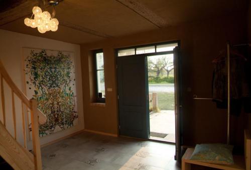 a hallway with a door and a window and a chandelier at Auszeit am Haff in Vogelsang