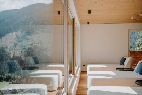 a row of beds in a room with a window at Hotel Berghaus Rosengarten in Nova Levante