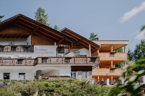 a house with a balcony on the side of it at Hotel Berghaus Rosengarten in Nova Levante