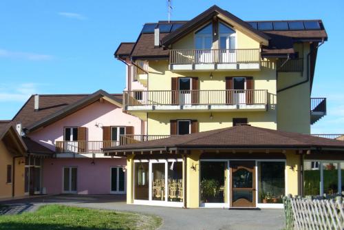 a large yellow and pink building with a balcony at Hotel Residence Bellavista - Camping Polsa in Brentonico