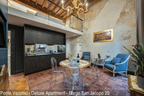 uma sala de estar com mesa e cadeiras e uma cozinha em Soggiorni D'Arte Apartments by Mamo Florence em Florença