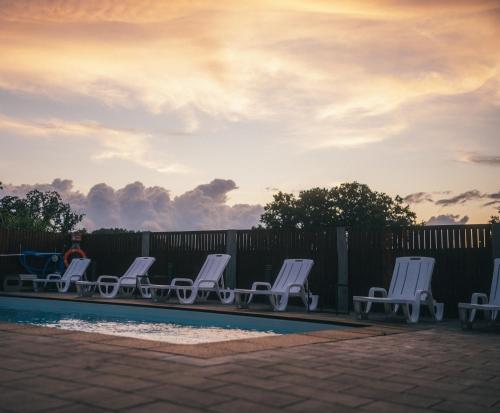 a group of chairs sitting next to a pool at Apartamenty Pod Dębami in Sarbsk