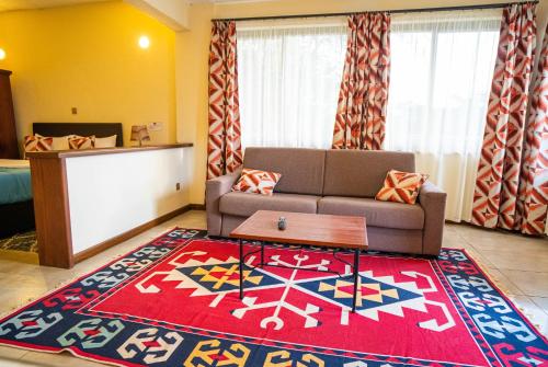 a living room with a couch and a red rug at Matteos Italian Restaurant,Bar & Accommodation in Naivasha
