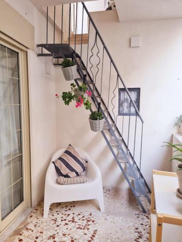 a living room with a staircase with potted plants at Mineo Townhouse with incredible views of Mt Etna in Mineo