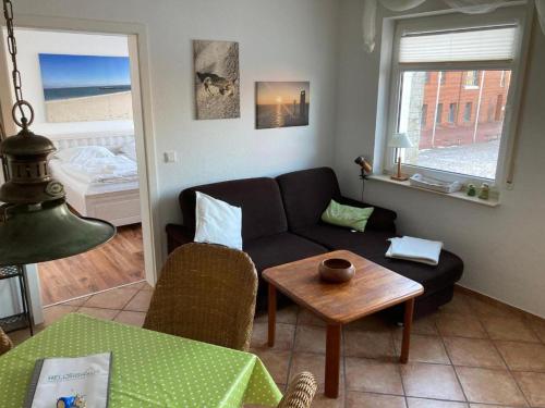 a living room with a couch and a table at Hellinghaus Wellenreiter in Wyk auf Föhr