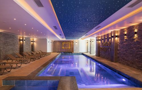 a swimming pool in a hotel with tables and chairs at Ground Garden View Apartments in Caesar Resort & SPA, Long Beach in Perivolia tou Trikomou