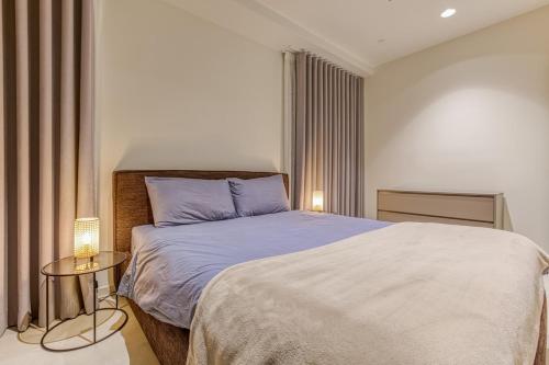 1 dormitorio con 1 cama grande y mesa auxiliar en 20th Floor, Mercury tower, en San Julián