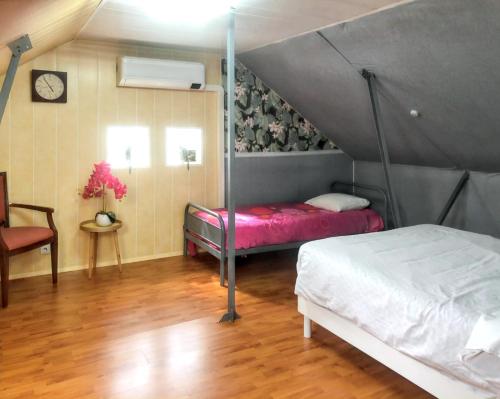 une chambre avec deux lits dans un grenier dans l'établissement Villa charmante à Saint-Martin-Longueau avec piscine privée, à Saint-Martin-Longueau