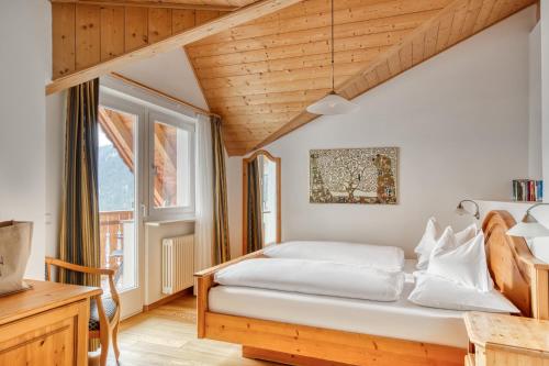a bedroom with a bed and a window at Hotel Berghaus Rosengarten in Nova Levante