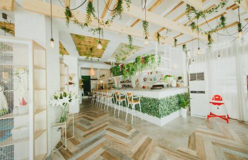 a kitchen with a bar with chairs and plants at Ground Garden View Apartments in Caesar Resort & SPA, Long Beach in Perivolia tou Trikomou